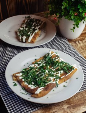 Restoranda tabakta peynirli krep. Kahvaltını kafede yap. Bir kadın kahvaltıda tek kullanımlık yemeklerden krep yer. Üst görünüm ve dikey fotoğraf