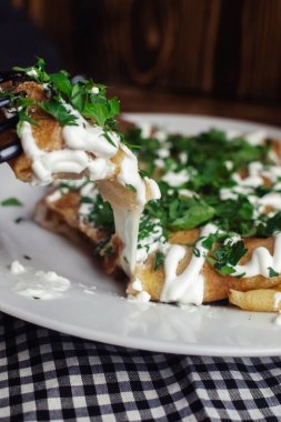 Restoranda tabakta peynirli krep. Kahvaltını kafede yap. Bir kadın kahvaltıda tek kullanımlık yemeklerden krep yer. Üst görünüm ve dikey fotoğraf