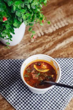 Tek kullanımlık kağıt bardaktaki bir balyozun yakın çekimi. Geleneksel yemek ve yabancı mutfak kavramı. Güvenli çevre dostu tek kullanımlık sofra takımı.