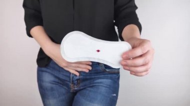 Hipomenoroz. Kadın üzerinde küçük bir damla kan olan jinekolojik bir ped gösteriyor. Regl döneminde küçük miktarlarda ilaç kullanımı. Ağrı ve garip bir döngü şikayetleri var. Jinekolojide hastalıklar