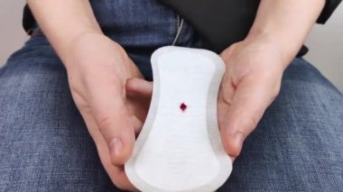 Hipomenoroz. Kadın üzerinde küçük bir damla kan olan jinekolojik bir ped gösteriyor. Regl döneminde küçük miktarlarda ilaç kullanımı. Ağrı ve garip bir döngü şikayetleri var. Jinekolojide hastalıklar