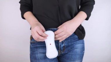 Hipomenoroz. Kadın üzerinde küçük bir damla kan olan jinekolojik bir ped gösteriyor. Regl döneminde küçük miktarlarda ilaç kullanımı. Ağrı ve garip bir döngü şikayetleri var. Jinekolojide hastalıklar