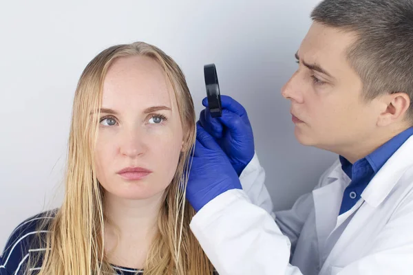 Bir trichologist yağlı saçlı bir kızı muayene ediyor. Sorunlu kafa derisi ve yağlı bezlerde artan salgı. Saç bakımı. Yağlı saç bakımı ve tedavi konsepti. Doktor tedavi öneriyor..