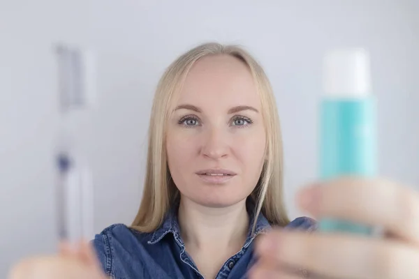 一个正在刷牙的女孩的特写镜头 看着镜子前面 口腔卫生 在清洁口腔的物品的手上 牙刷和牙膏 因白人背景而被隔离 — 图库照片