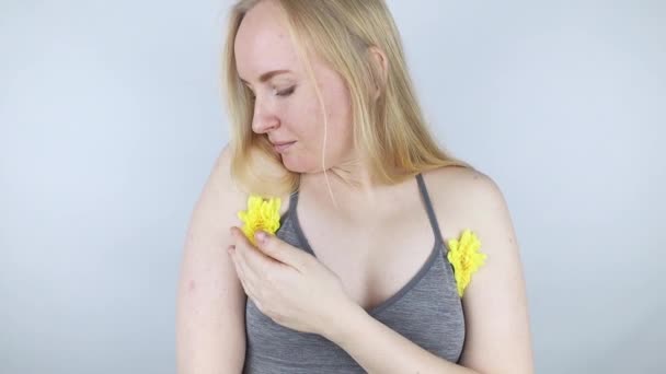脇から心地よい匂いがするというコンセプト 女の子は腕と胸の間に黄色い花を挟まれている ボディケア 女性の健康 女性の自然との闘い — ストック動画