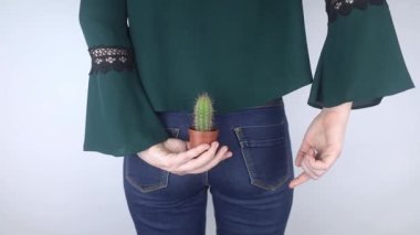 Kavram. Bir kadın rektal ağrının sembolü olarak kaktüs tutuyor. İnce bağırsağın varis damarları. Rektum ağrısı, hemoroit ve vücudun dışkılama sisteminde ağrı. Proktoloji