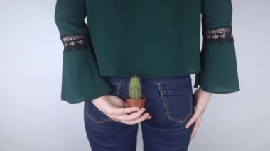 Kavram. Bir kadın rektal ağrının sembolü olarak kaktüs tutuyor. İnce bağırsağın varis damarları. Rektum ağrısı, hemoroit ve vücudun dışkılama sisteminde ağrı. Proktoloji