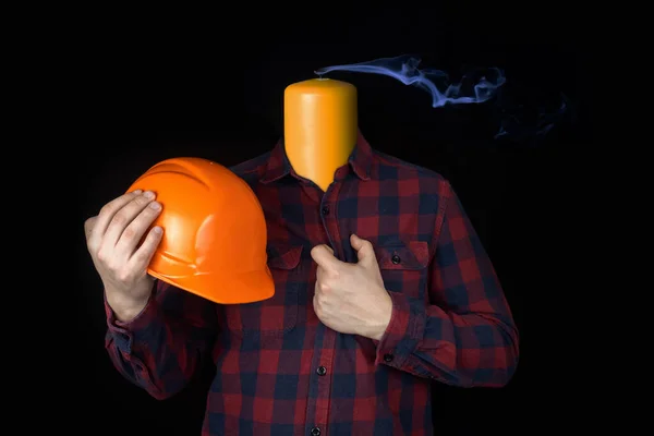 Match concept. A worker with a helmet in his hands. A symbol of fatigue and desire to change profession. Work burnout. Psychological problems. Professional crisis. Depression and desire to quit
