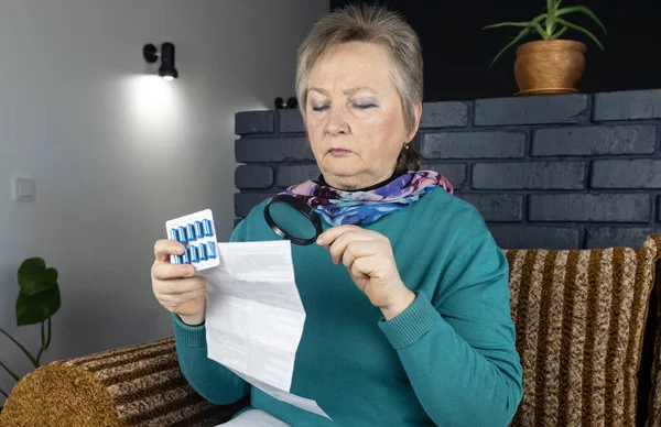 Senior woman reads instructions for medicines. Woman looks at the list and composition of the drug. Concept home self-medication and study of the properties of drugs. Contraindications. How to use
