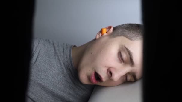 Man Puts Earplugs Close Orange Noise Barrier Deep Sleep Ent — Vídeos de Stock