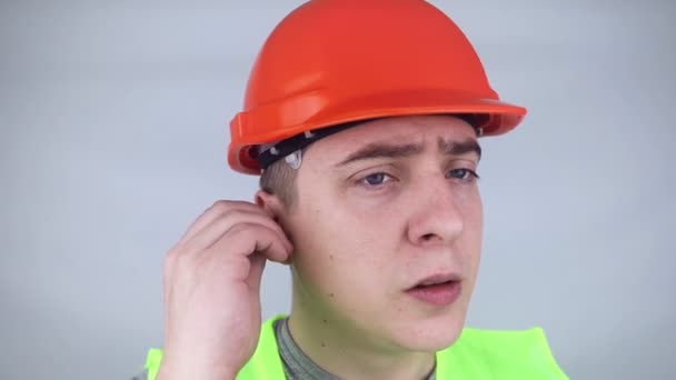 Worker Hard Hat Green Vest Puts Ear Plugs Industrial Safety — Stockvideo