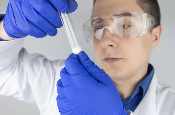 Medical laboratory assistant checks a test tube with sperm. Spermogram. Male fertility test. Semen in a test tube. Reproductive system check. Donor suitability test for artificial insemination