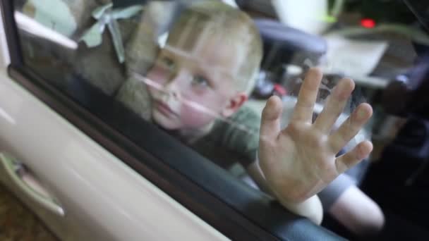 子供は車に閉じ込められている 金髪の少年は水なしで自動車で閉じられます 彼は熱く 顔は赤くなっている 無責任な両親は子供を熱い車の中に置き去りにした 子供のための貧しいケアの概念 — ストック動画