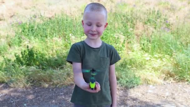 Dítě Rádiem Řízený Vrtulník Blonďatý Chlapec Drží Ruce Miniaturní Model — Stock video