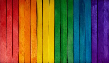 Colorful wooden background and backdrop with a vertical wooden row with rainbow lgbt flag colors.