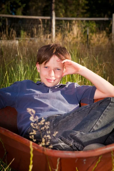 Casual jonge jongen in een kruiwagen — Stockfoto
