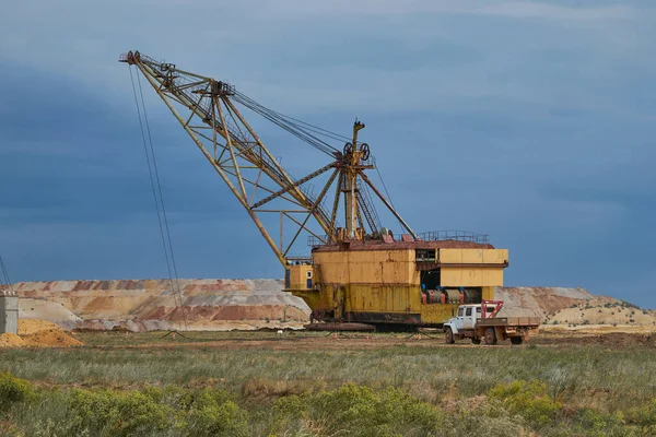 An old walking excavator is getting ready for work. Excavator in an iron mining quarry