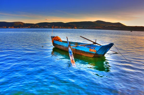 Traditional fishing red boat at sunset time in lake — Stock Photo, Image