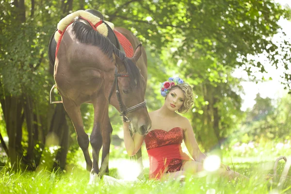 Kvinna med ljusa makeup på häst utomhus Stockfoto