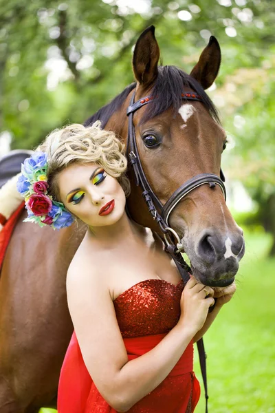 घोड़े के बाहर उज्ज्वल मेकअप वाली महिला स्टॉक तस्वीर