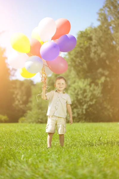 Сhild with a bunch of balloons in their hands — Stock Photo, Image