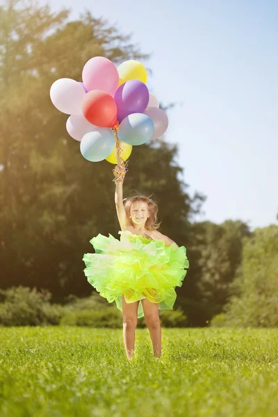 ? hild met een bos van ballonnen in hun handen — Stockfoto