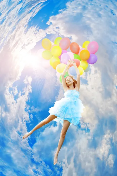Vrouw bedrijf ballonnen tegen zon — Stockfoto