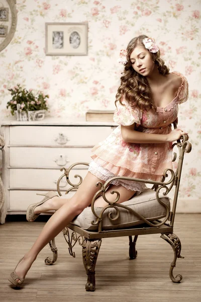Donna seduta in una stanza con un interno vintage — Foto Stock