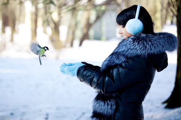 Jonge vrouw winter vogels voeden — Stockfoto