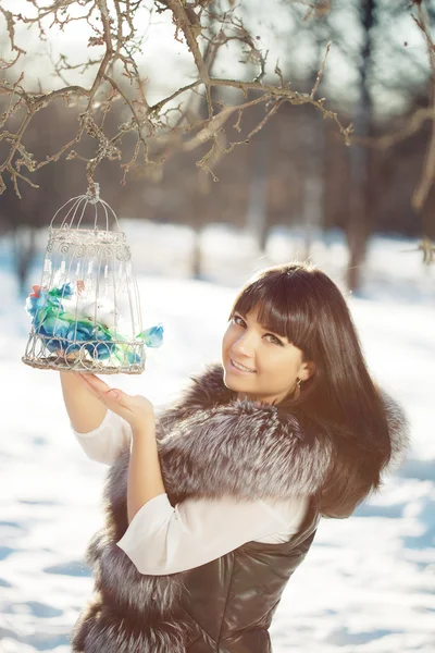 Giovane donna e uccelli invernali in gabbia — Foto Stock
