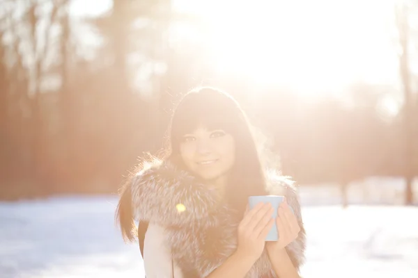 Jeune femme avec une tasse de boisson chaude — Photo