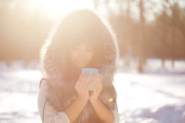 Jeune femme avec une tasse de boisson chaude — Photo