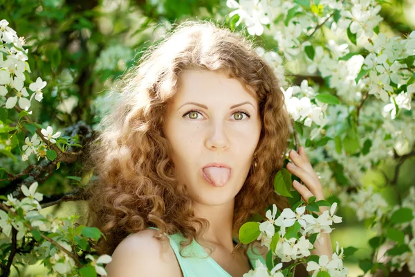 Mladá žena v rozkvetlé zahradě — Stock fotografie