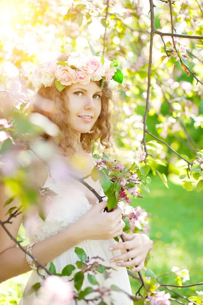 Unga skönhet kvinna i blommande trädgård — Stockfoto