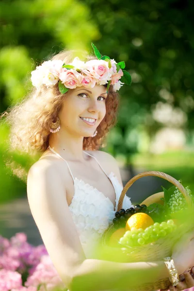 Mujer con una cesta de fruta en la mano — Foto de Stock