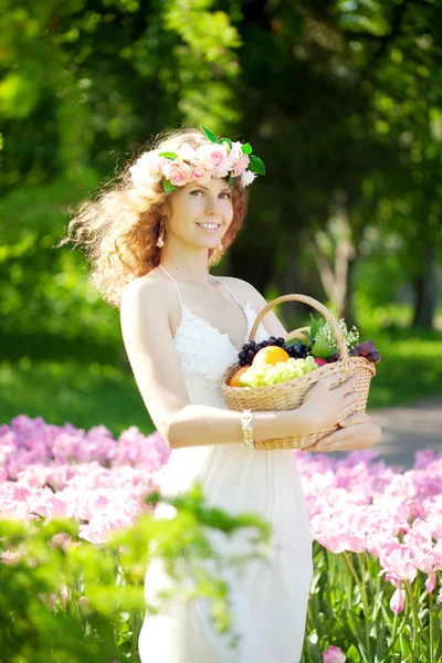 Mujer con una cesta de fruta en la mano —  Fotos de Stock