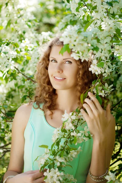 Giovane donna in giardino fiorito Immagini Stock Royalty Free