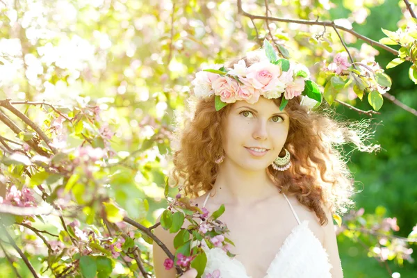 在盛开的花园的年轻美丽女人 图库图片