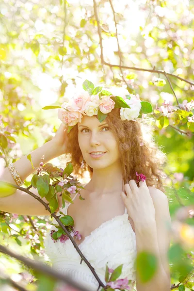 Giovane donna di bellezza in giardino fiorito Immagini Stock Royalty Free