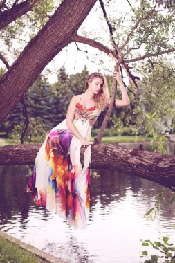 kadın ormanda uçan parlak elbise