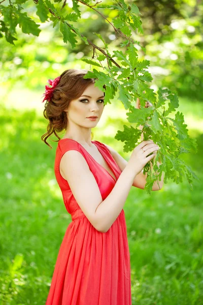 Vacker kvinna med en blomma i frisyren — Stock fotografie