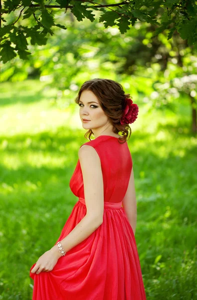 Vacker kvinna med en blomma i frisyren — Stock fotografie