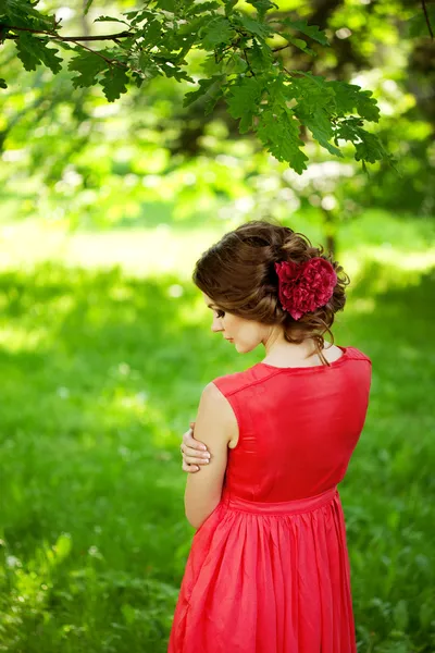 Красивая женщина с цветком в прическе — стоковое фото