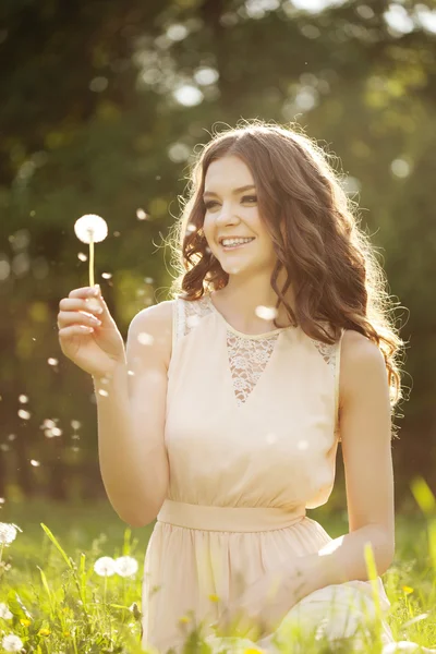 Hermosa mujer soplando un diente de león —  Fotos de Stock