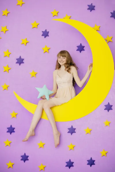 Chica sentada en la luna juguete — Foto de Stock