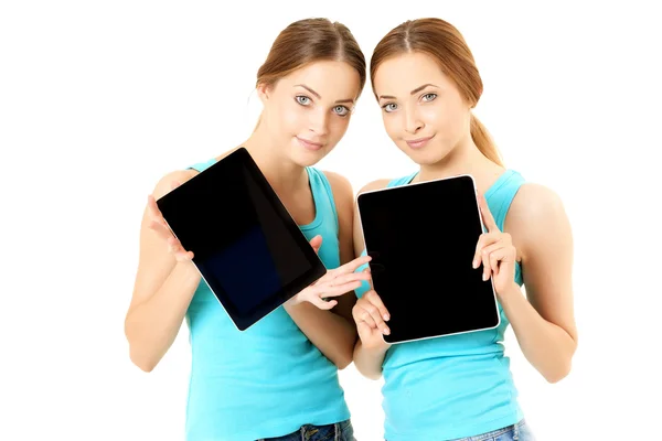 Dos mujeres sonrientes sosteniendo la tableta — Foto de Stock