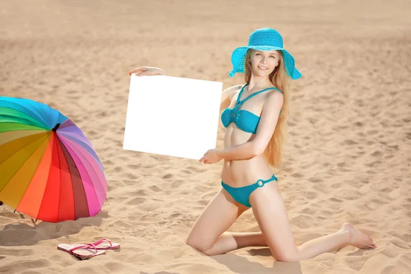 Woman holding white blank poster on the beach — Stock Photo, Image