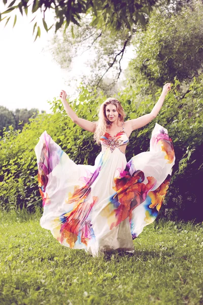 Femme en robe brillante volant dans la forêt Images De Stock Libres De Droits