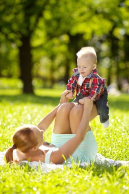 Şirin Bebek anne çim ile parkta. tatlı bab