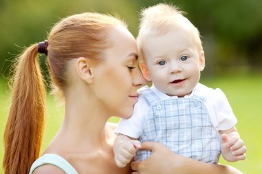 Şirin Bebek anne çim ile parkta. tatlı bab